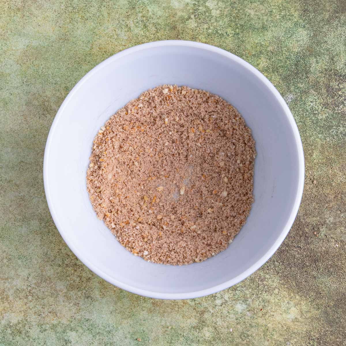 Orange-sugar mixture, cinnamon, nutmeg, and cardamom whisked together in a ceramic bowl