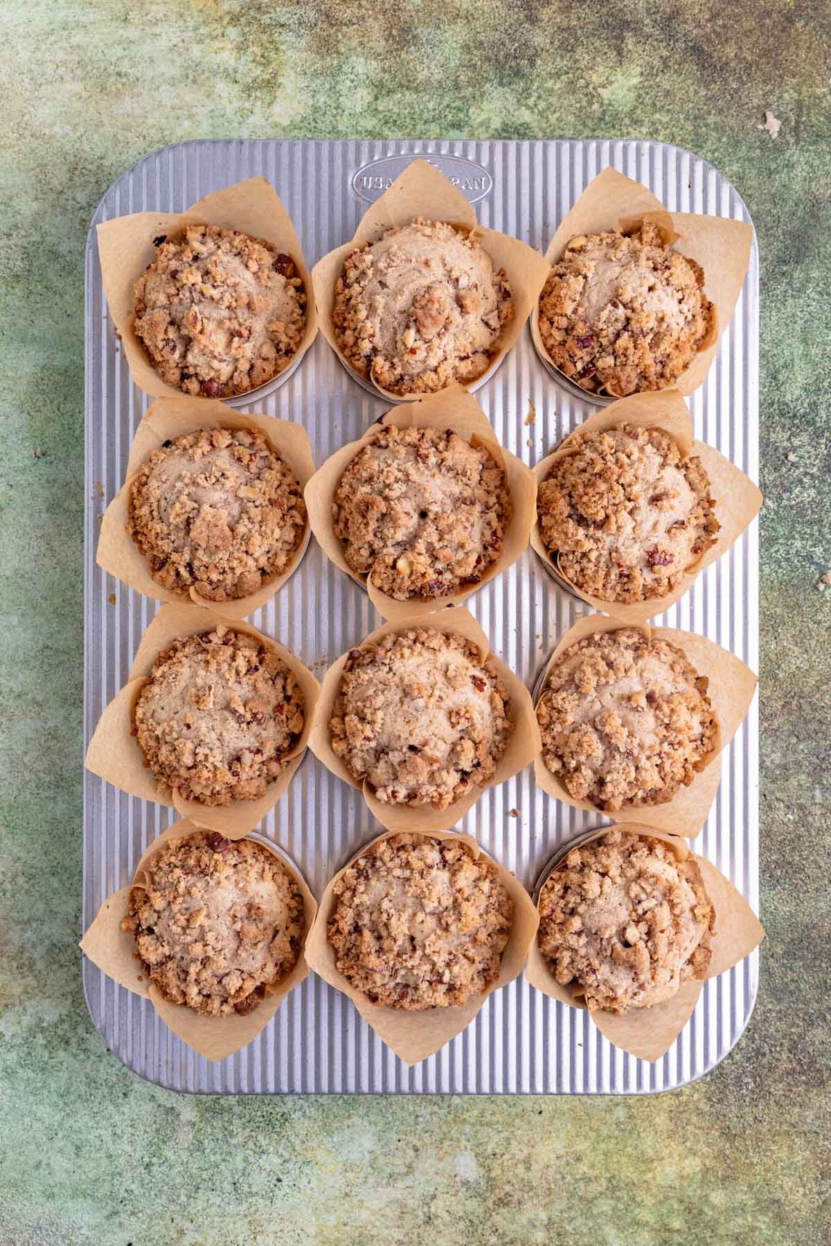 Baked apple streusel muffins in a 12 cup muffin pan