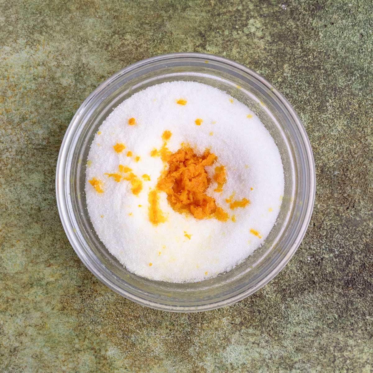 Granulated sugar and orange zest in a small glass bowl