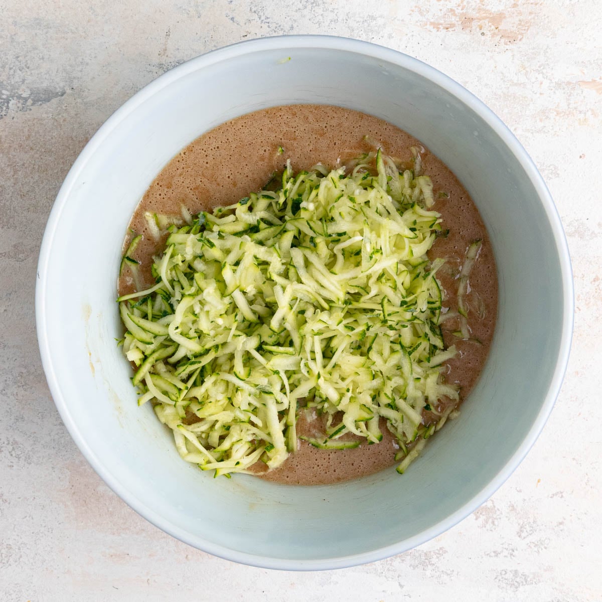 The grated zucchini added to the zucchini bread batter